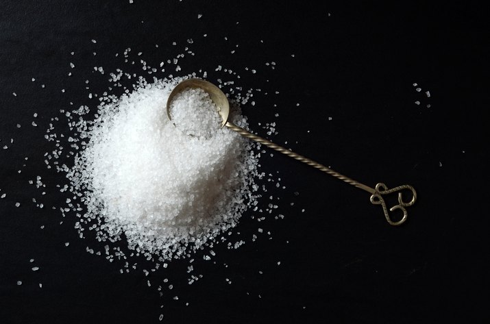 Salt with a spoon on a dark background