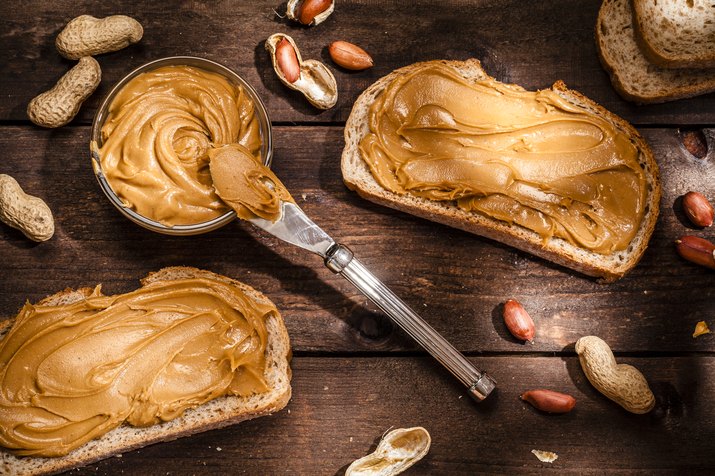 Peanut butter on toast shot on rustic wooden table