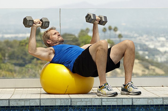 Man doing stability ball bench press exercise for better sex