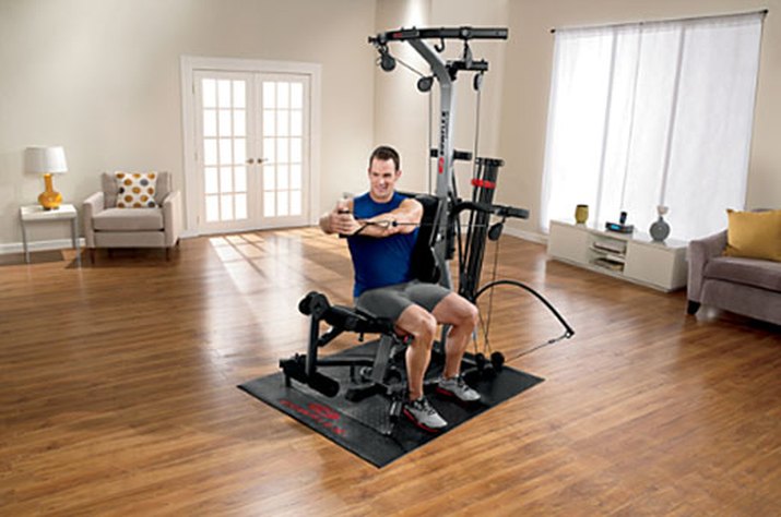 Portrait of man using exercise equipment in gymnasium