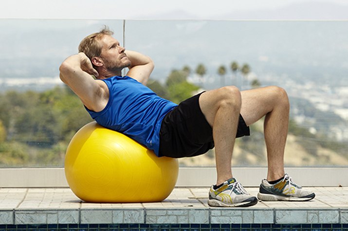 Man doing stability ball crunch exercise for better sex