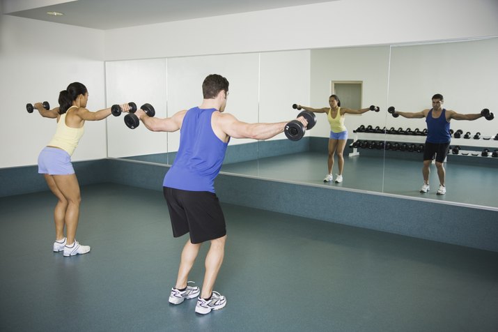 Man and woman lifting weights at gym
