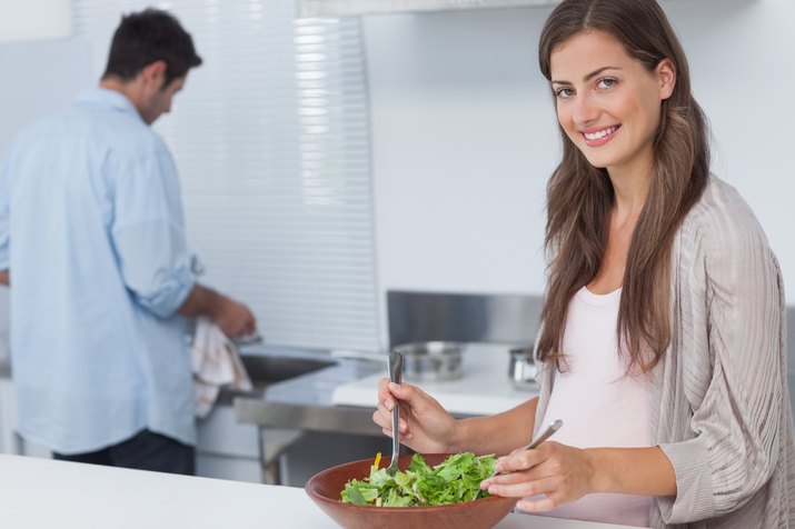 Woman mixing a salad in the kitchen