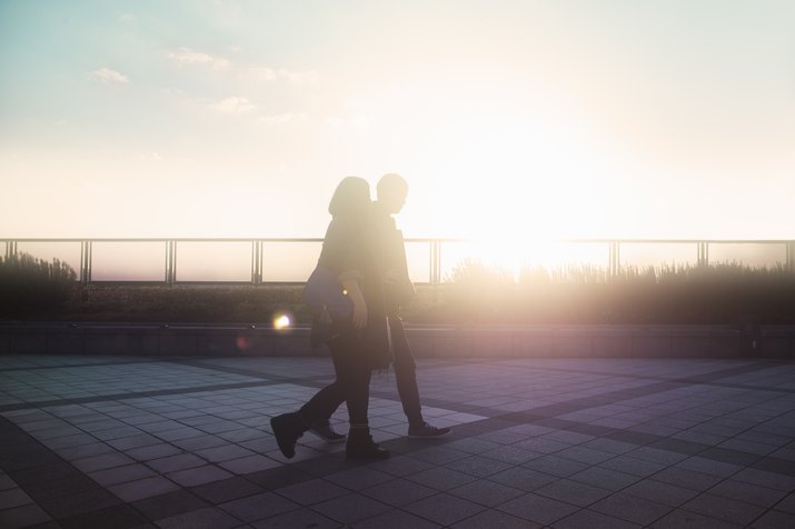 Couple walking on the pavement at sunset