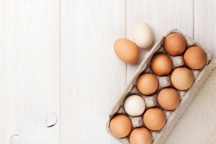 Cardboard egg box on wooden table for muscle building diet