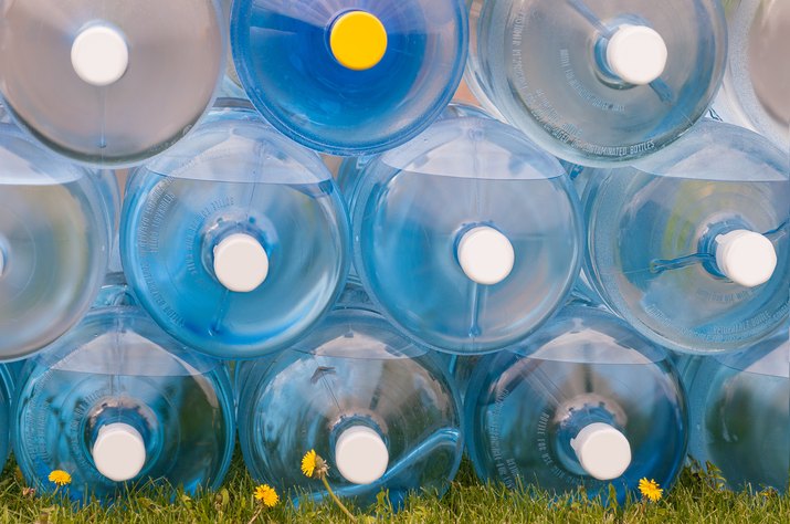 Water Jugs Stacked on Grass