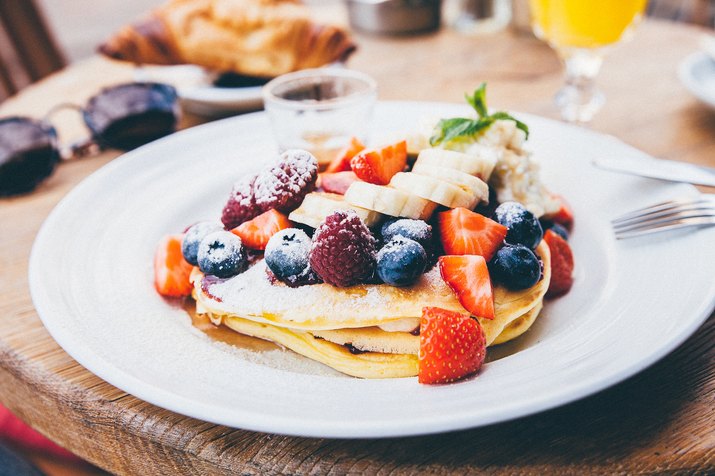 A stack of pancakes topped with fruit