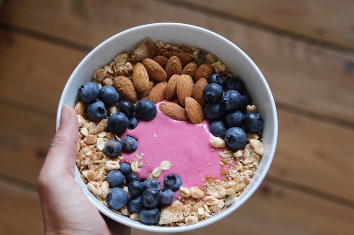An acai bowl topped with almonds, blueberries and granola