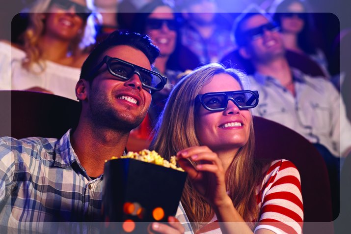 Couple enjoying popcorn at a 3D movie