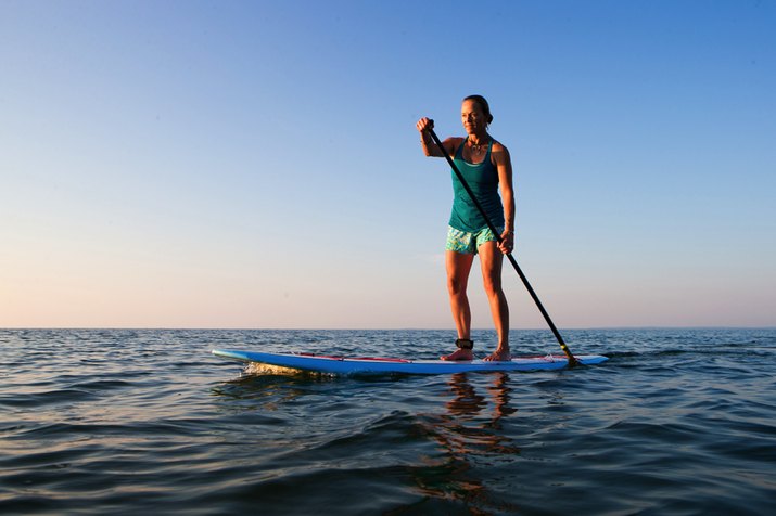 fit woman paddleboarding
