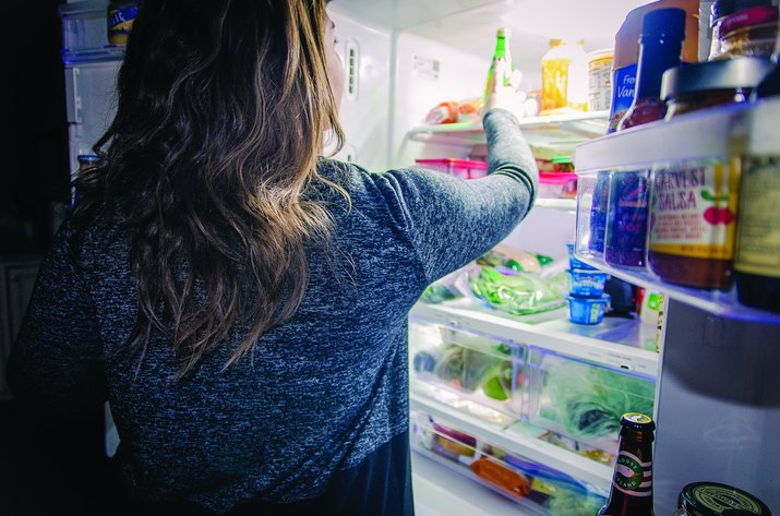 Woman getting a snack from a fridge