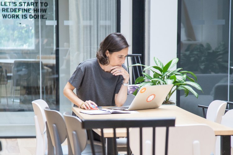 Julie Campistron working on her laptop in the stop breathe think office