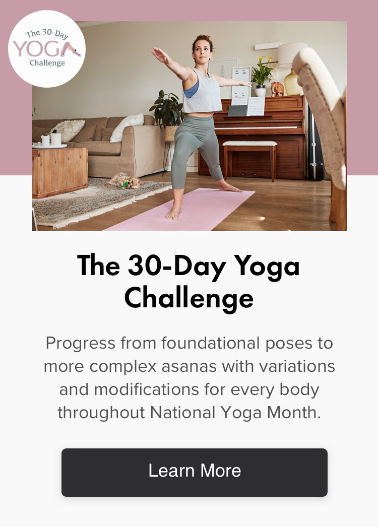 woman doing yoga in living room on pink yoga mat on wood floor