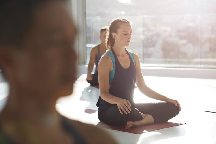 Woman meditating in a studio at sunset