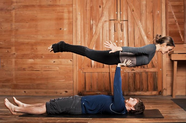 A man and woman balancing Acroyoga or flying yoga