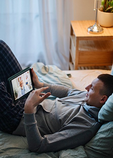 person accessing affordable health care via telehealth from bed