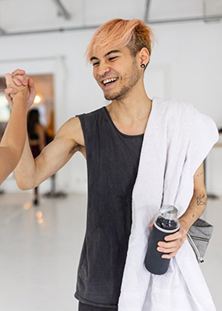 two people in fitness studio high fiving with healthy relationship with exercise